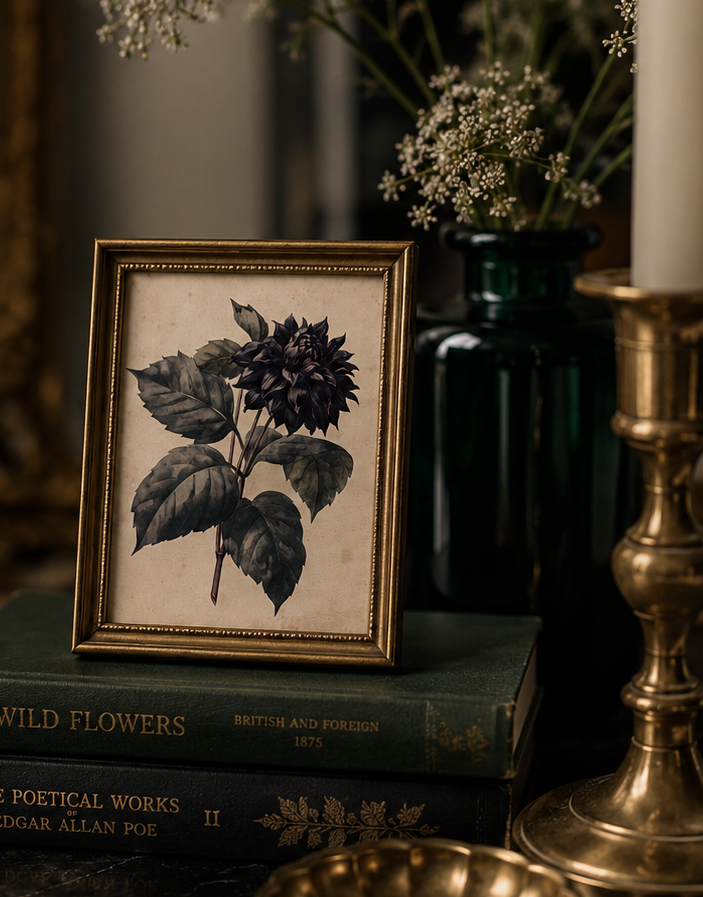 Framed botanical print on books with a candle and decorative elements in the background